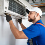 Technician servicing an air conditioning unit.