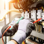 Electrician testing a circuit with a multimeter.